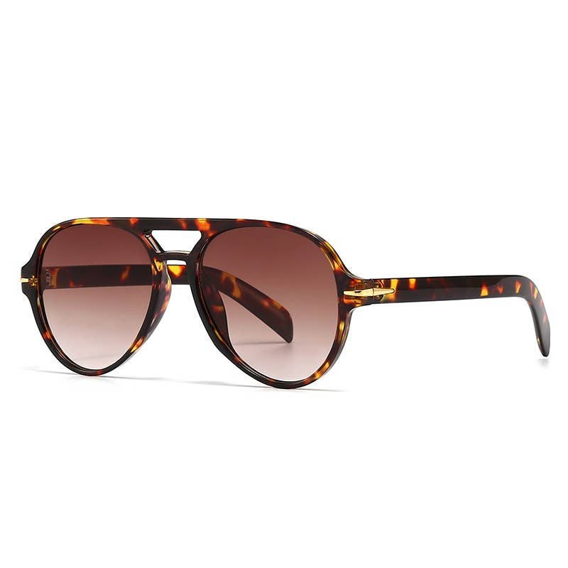 Tortoiseshell sunglasses with brown gradient lenses on a white background