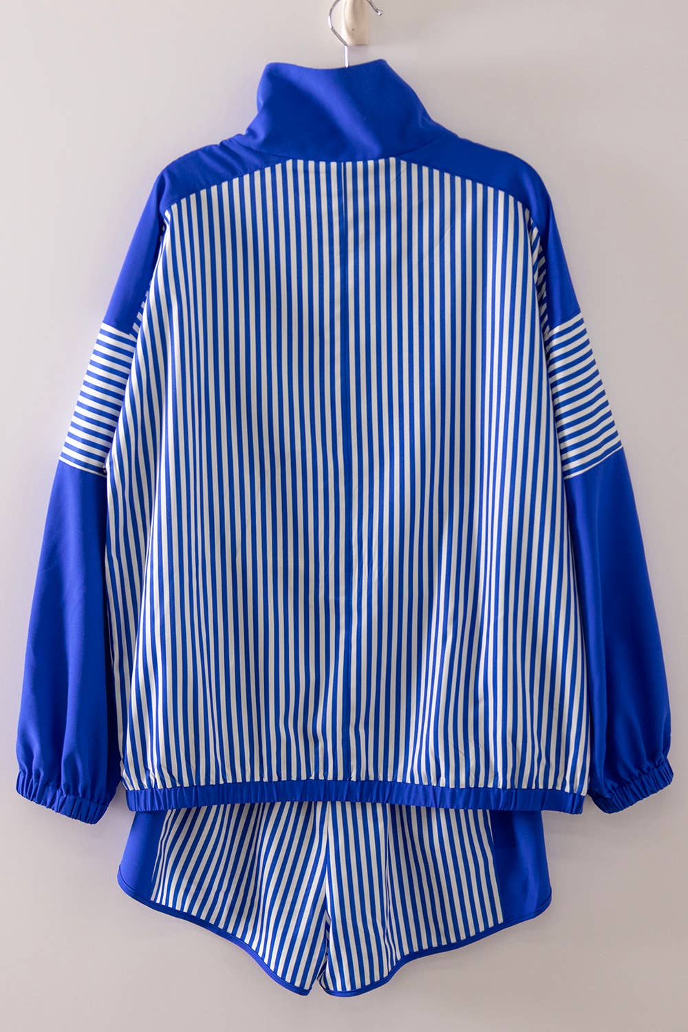 Blue and white striped jacket and pants set on a plain background