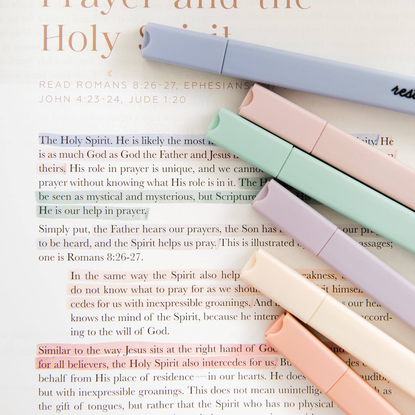 Pastel-colored markers on an open book with text