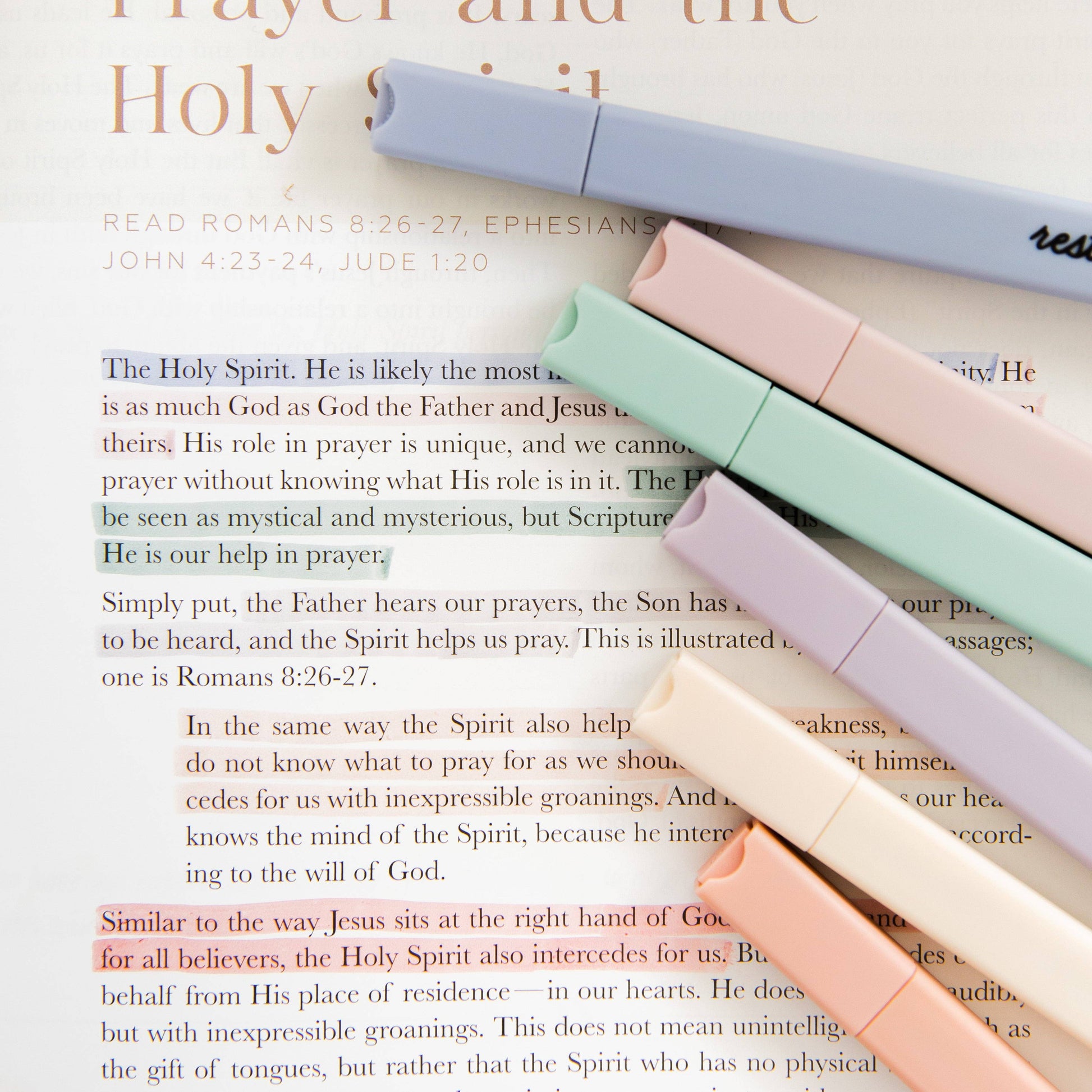 Pastel-colored markers on an open book with text