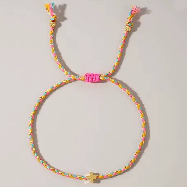 Colorful braided bracelet with a small charm on a light gray background