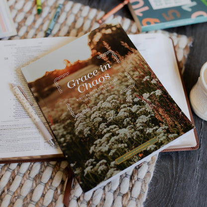 Book titled 'Grace in Chaos' on a surface with other books and stationery items.