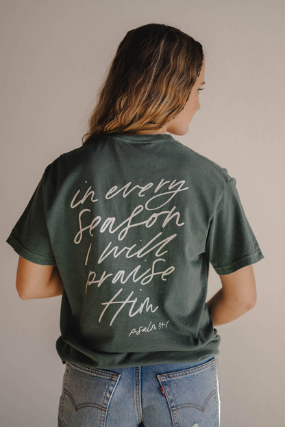 Person wearing a green t-shirt with a motivational quote on the back against a neutral background