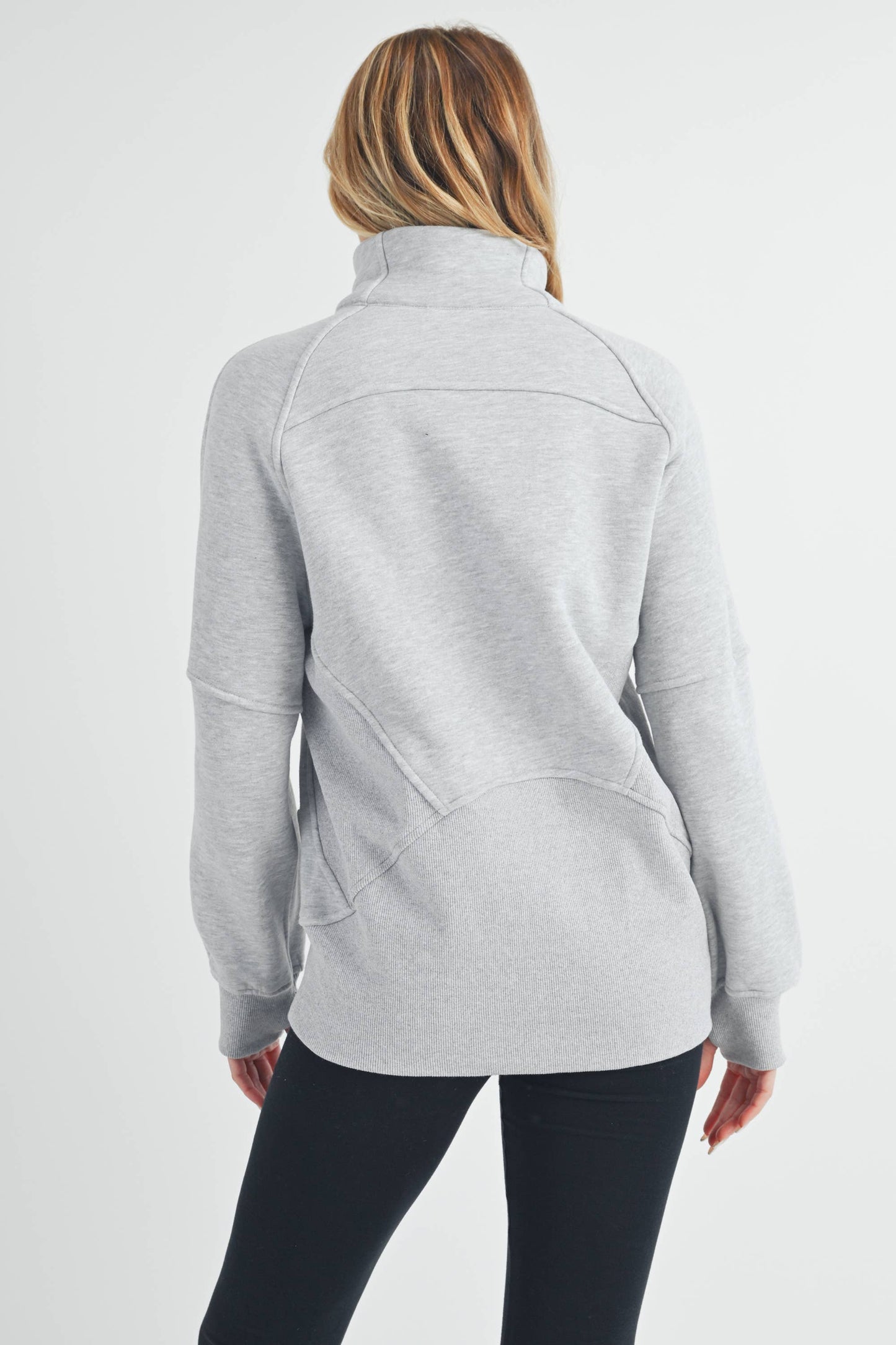 Person wearing a gray fleece jacket on a white background