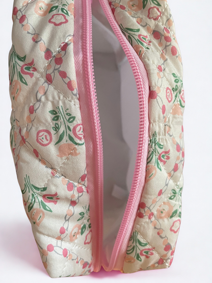 Floral-patterned pouch with a pink zipper on a light pink background