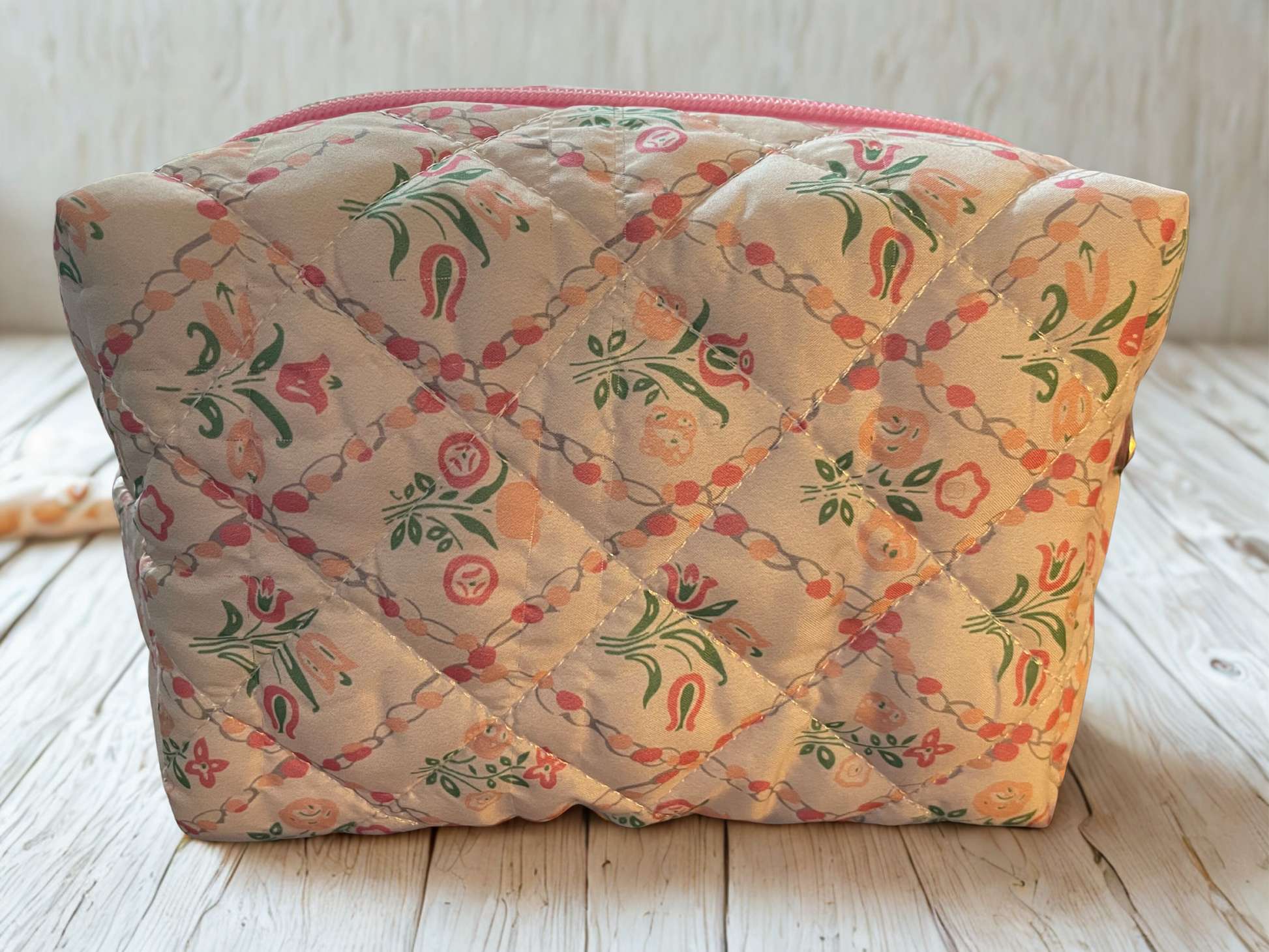 Quilted fabric bag with floral pattern on a wooden surface