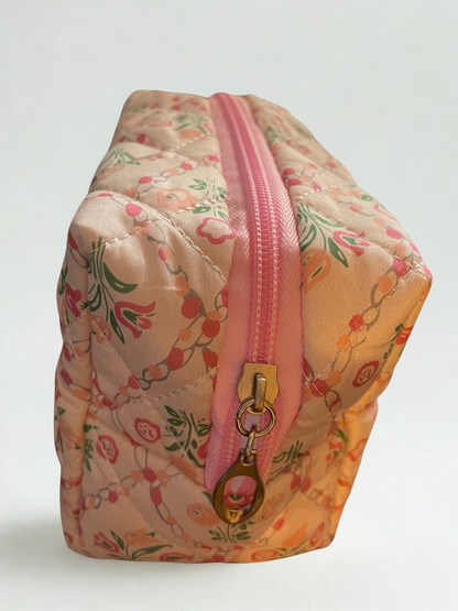 Floral-patterned pouch with a pink zipper on a light gray background