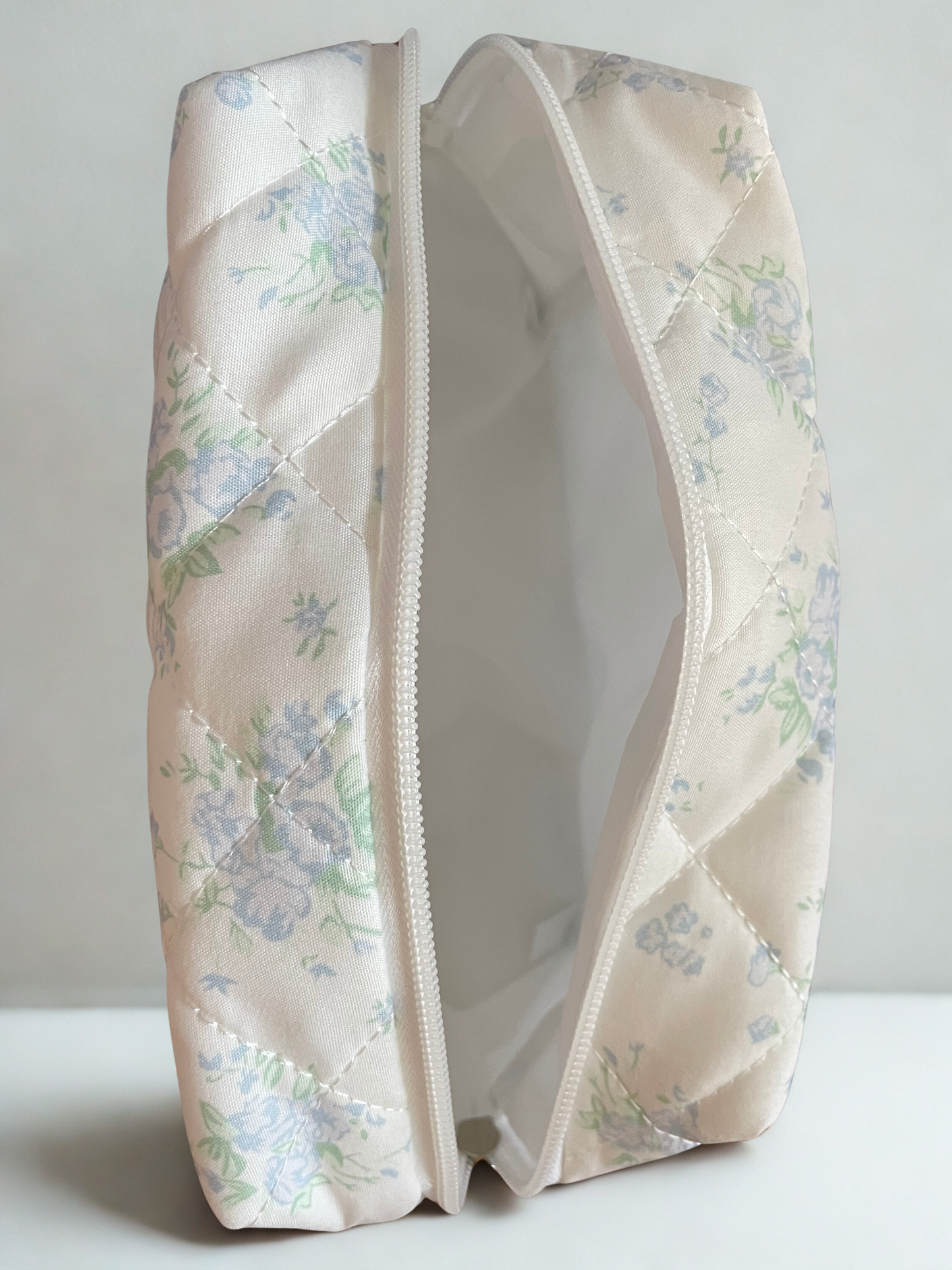 Floral-patterned makeup bag on a white background