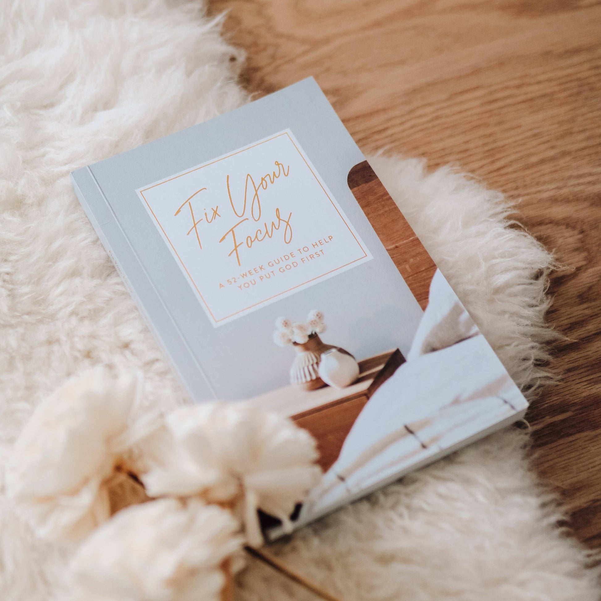 Book titled 'Fix Your Focus' on a fluffy white surface with a wooden background
