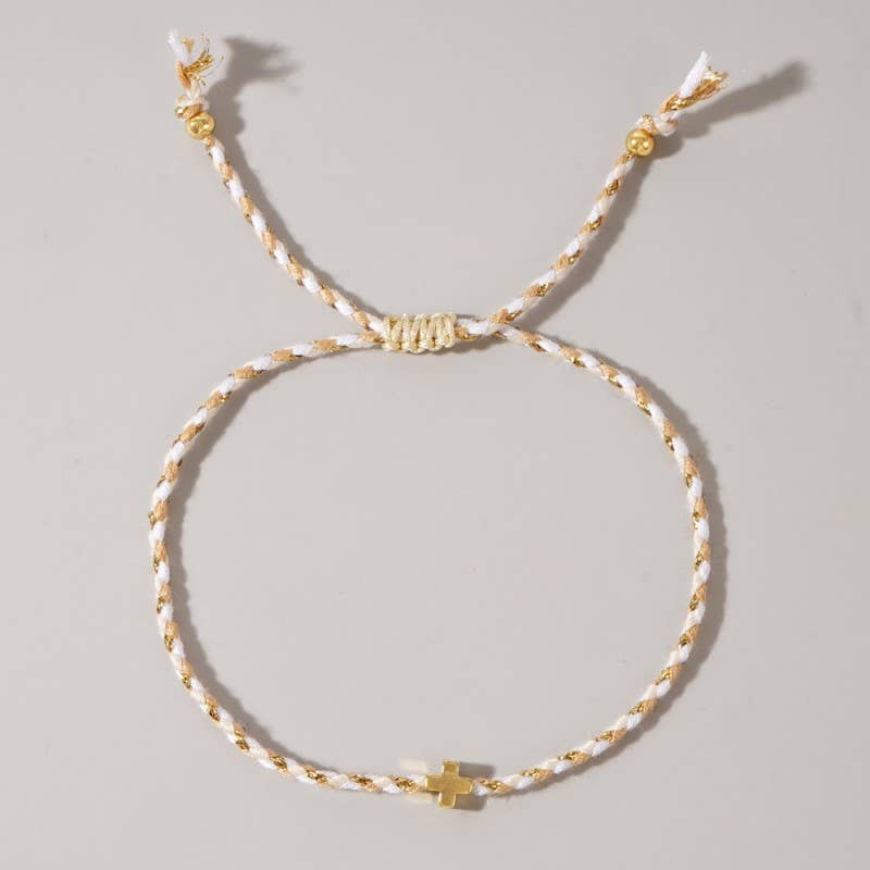Bracelet with gold and white cord on a light gray background