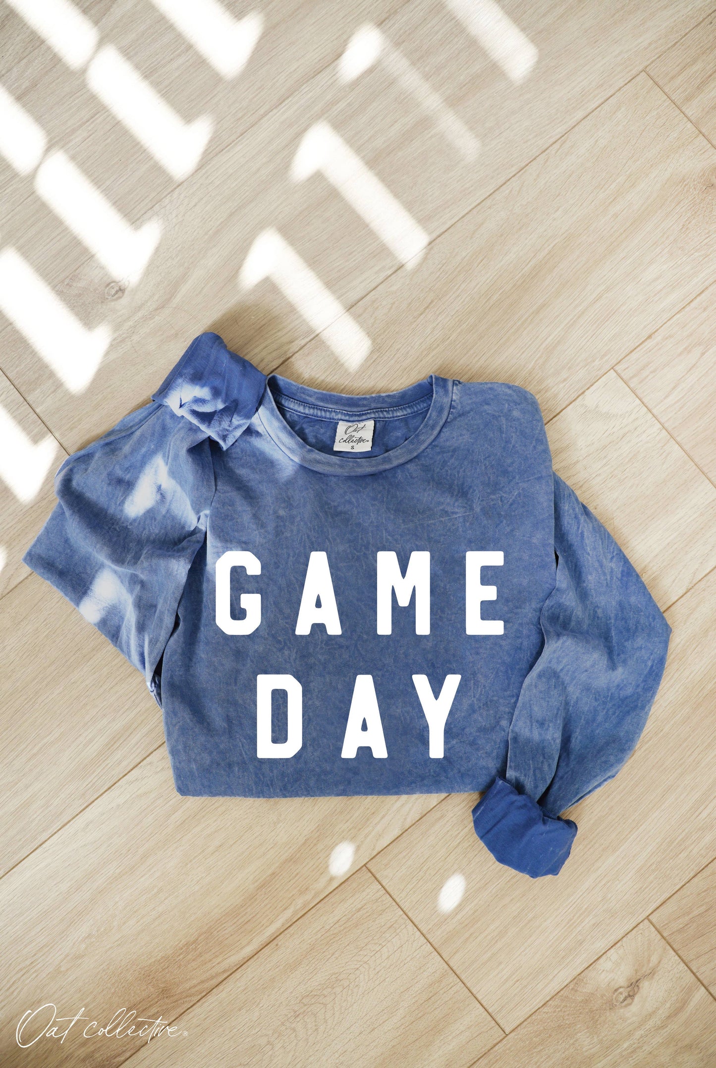 folded mineral washed blue sweatshirt with the words "GAME DAY"